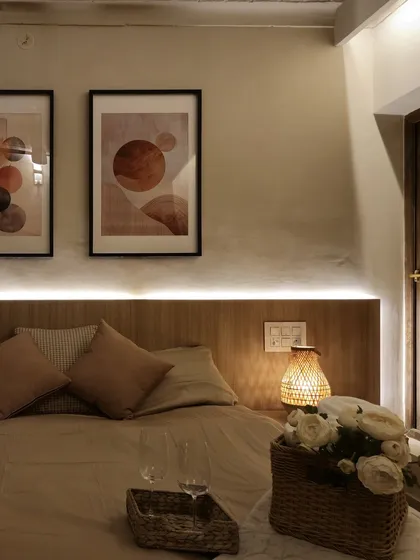 In this bedroom at the Coorg villa, we used a wooden headboard with integrated LED strip lighting to create a soft, ambient glow. The warm lighting highlights the earthy color palette and natural textures, fostering a restful environment.