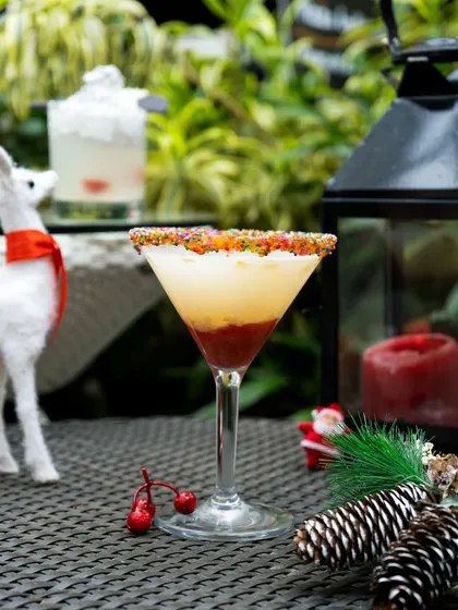 A beautiful Christmas cocktail with a sprinkle-rimmed glass, embodying the spirit of the season in every sip.