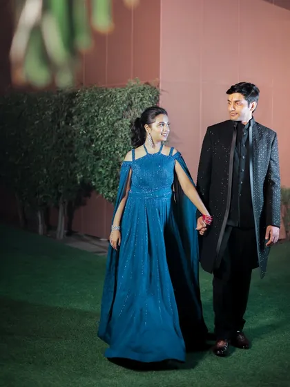 Avichal and Somya share a walk during their engagement shoot at the Taj Hotel in Agra. The bride's flowing blue gown and the groom's classic black attire create a striking contrast.