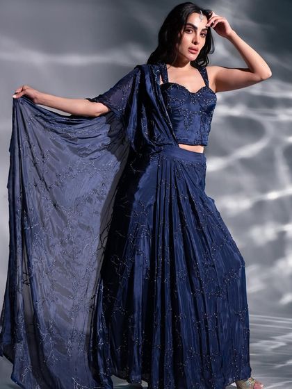 A full-length shot of the stunning navy blue sharara set. The makeup is glamorous and defined, perfect for a sangeet or cocktail party.