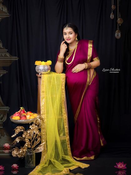 A full-length portrait showcasing the elegance of the traditional saree and props. This setup is designed to create a feeling of timeless Indian royalty.