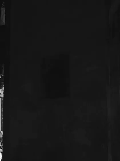 A dramatic black and white photo using light and shadow to create a sense of mystery and romance within a historic Delhi location. This is an example of our moody, artistic couple photography.