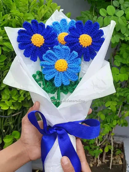 A striking bouquet of blue crochet daisies, showcasing how we can create flowers in unique, unconventional colors. The different shades of blue add depth and visual interest.