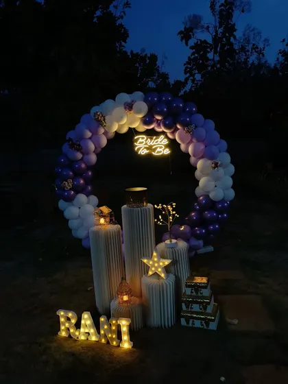 This is a more atmospheric view of the outdoor 'Bride to be' setup, captured just as night falls. The glow from the neon sign, marquee letters, and decorative stars creates a captivating and intimate feel for a special evening celebration.