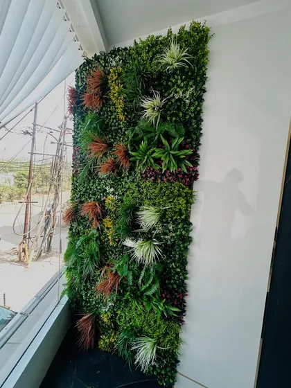 A vertical garden panel installed next to a large window, bringing the feeling of the outdoors inside.
