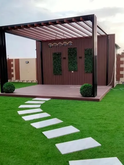 A pergola can serve as the stunning centerpiece of your landscape. In this garden, the structure creates a defined entertainment stage, complemented by a curved stepping stone path and lush artificial turf.