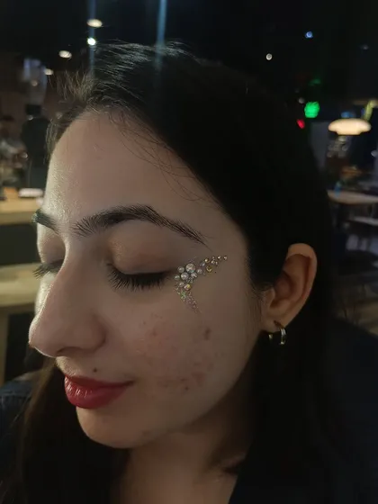 I call this the angel wing design. It's a soft, ethereal look created with pearls and iridescent rhinestones that cascade down the cheek.