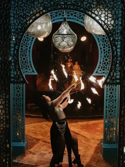 A fire dancer performs within a Moroccan-style archway, setting a dramatic and mystical tone for the Arabian Sufi Night. I use live performers to bring authenticity and excitement to themed events.
