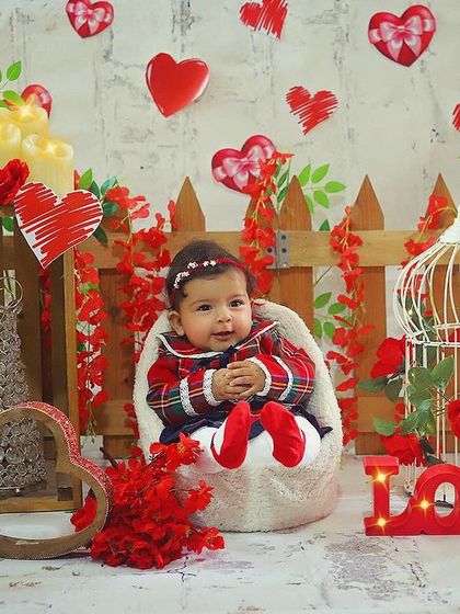 This little sweetheart is ready for Valentine's Day! Her adorable plaid dress and the heart-filled background make for a lovely and festive portrait.