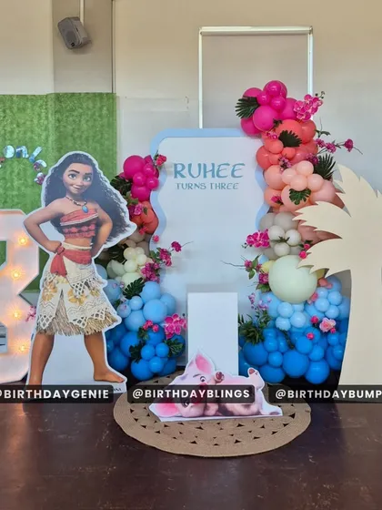 A Moana theme for a third birthday, with a life-sized character cutout and a light-up number '3'. The tropical-colored balloons add to the island vibe.