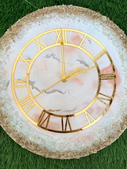 This clock features a soft pink and white marble design with a full border of sparkling gold and white crystals.