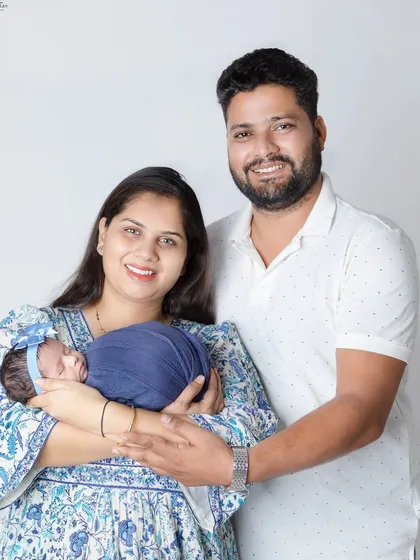 A happy new family of three. The coordinated blue and white outfits look so fresh and beautiful.
