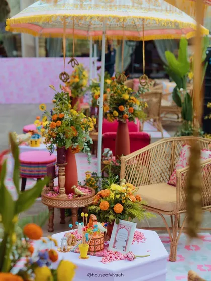 A close-up of a lounge area with rattan furniture and a table adorned with marigolds, showcasing the blend of bohemian and traditional styles.