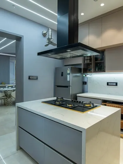 This kitchen marries contemporary minimalism with soul-satisfying functionality. The soft blue-gray cabinets, stone countertops, and floating island create a tranquil yet sophisticated atmosphere.