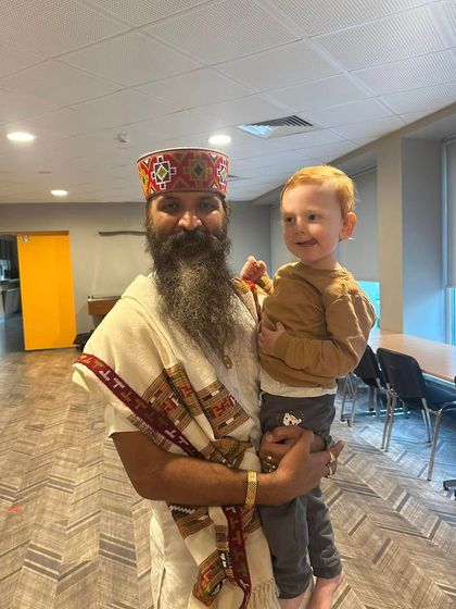 Holding a young child in my arms. Children are the future, and the habits of mindfulness and compassion we instill in them today will shape the world of tomorrow.