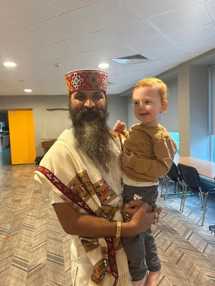 Holding a young child in my arms. Children are the future, and the habits of mindfulness and compassion we instill in them today will shape the world of tomorrow.
