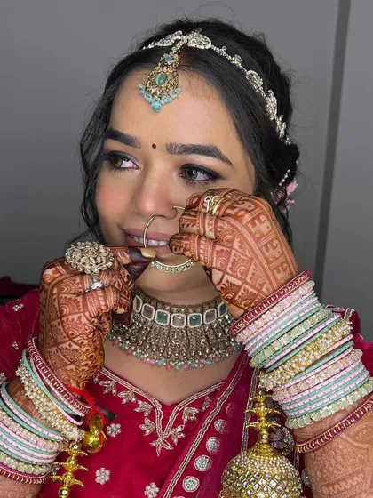 Adjusting the nose ring, a classic bridal moment. This photo showcases the flawless skin work and how the makeup holds up beautifully.