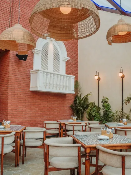 A European-inspired faux balcony is set against a rustic red brick wall, adding a touch of old-world romance and architectural whimsy. This detail creates a memorable photo opportunity and enhances the venue's unique character.