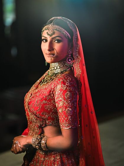 A regal bridal look with a dramatic, dark smokey eye and heavy jewelry. This demonstrates the high-impact, glamorous makeup you will learn to create for grand weddings.