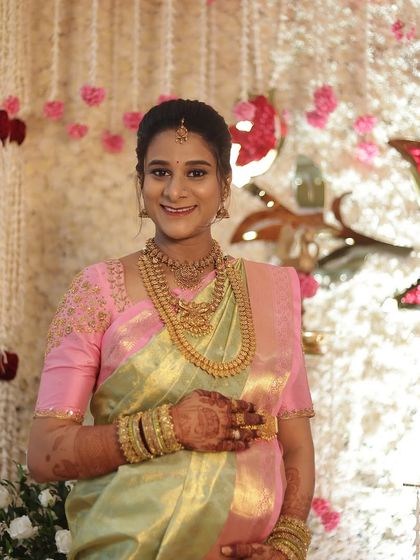 Savitha cradling her baby bump, looking radiant and happy. The makeup is designed to celebrate her pregnancy glow.