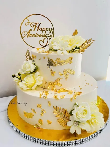 Celebrating love with this elegant two-tier anniversary cake. I used delicate white flowers and touches of gold leaf to create a timeless and sophisticated look. It’s a perfect example of how I design cakes for adult milestones like anniversaries and engagements.