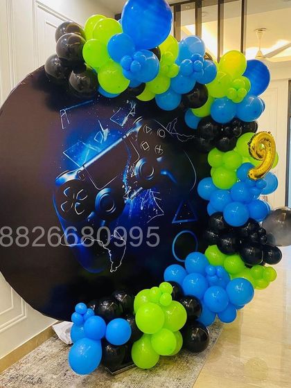 Another view of the gaming-themed birthday decoration, showing the dynamic arrangement of the balloon garland around the circular backdrop.
