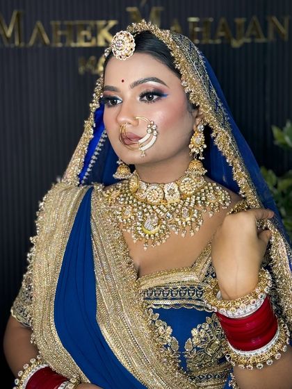 A side profile of the Rajputi bride, showcasing her elegant bun, traditional jewelry, and the flawless finish of her HD makeup against the studio backdrop.