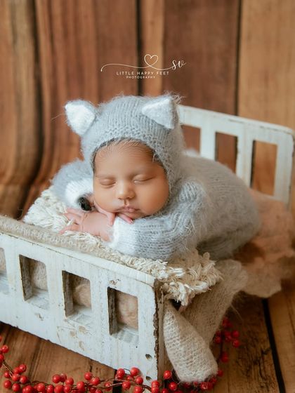 This little cat is sleeping soundly in his tiny bed. The gray and white color scheme is modern and serene, perfect for a minimalist nursery.