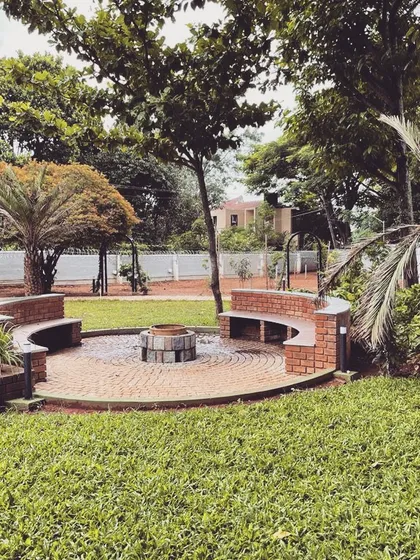 For this expansive farmhouse lawn, we built a custom circular fire pit area with integrated brick seating. This hardscaped feature creates a natural gathering spot for family and friends, perfect for cool evenings under the stars.