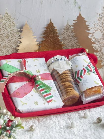 A beautifully wrapped Christmas hamper with festive paper and ribbons, filled with our delicious handmade treats.