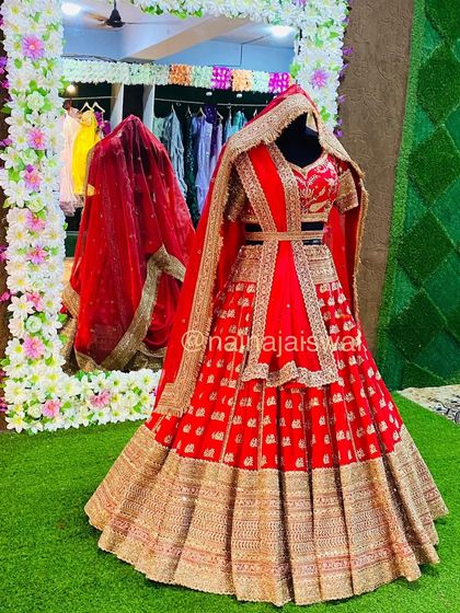 A full view of a stunning red bridal lehenga, featuring a belted dupatta style. This shows how we can style the same outfit in different ways for various functions.