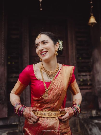 The radiant smile of Elisabetta, an Italian bride embracing Indian traditions. Her joy in wearing the red saree is a beautiful testament to cross-cultural love.