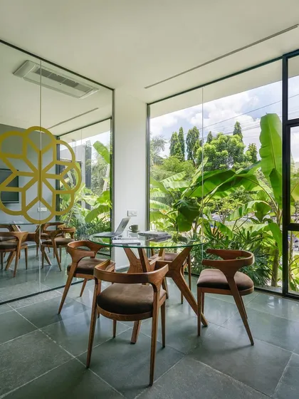One of the glass-walled discussion rooms at Soul Spring, designed to feel open and connected to nature. The large windows look out onto a lush courtyard, creating a refreshing and inspiring environment for meetings.