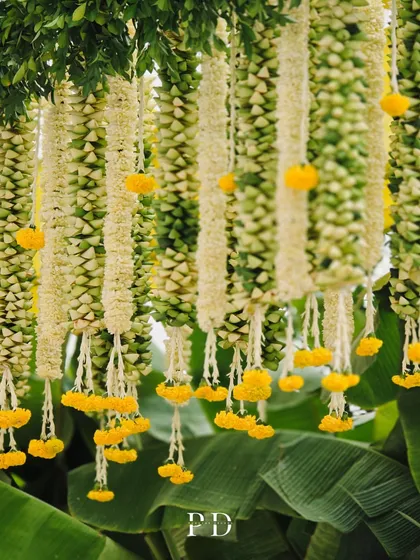 A close-up of the intricate hanging floral garlands, made from tuberose and marigolds. The craftsmanship and detail in our floral work is something we take great pride in.