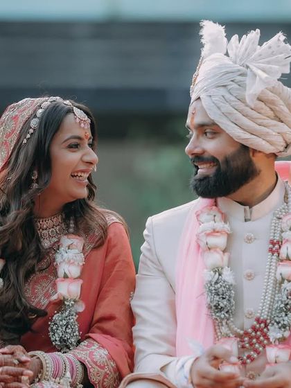 The bride and groom share a laugh while seated during their wedding ceremony.