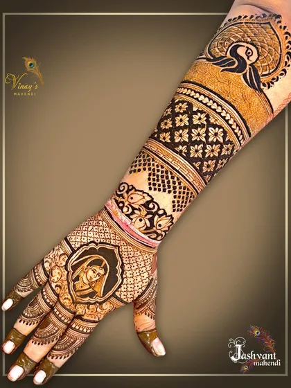 This back-hand design features a lovely bride's portrait, complemented by a bold peacock motif on the forearm, blending portraiture with classic henna art.