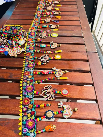 The 'Tamaara' toran laid out, showcasing all its elements before it gets packed. You can see the embroidered lace, wooden beads, and ghungroos ready to bring joy to a new home.