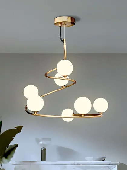 A spiral-shaped chandelier like this one adds a playful and dynamic element to any room. The globe lights provide even illumination, and the gold finish gives it a touch of luxury. It works well over a dining table or in a living room.