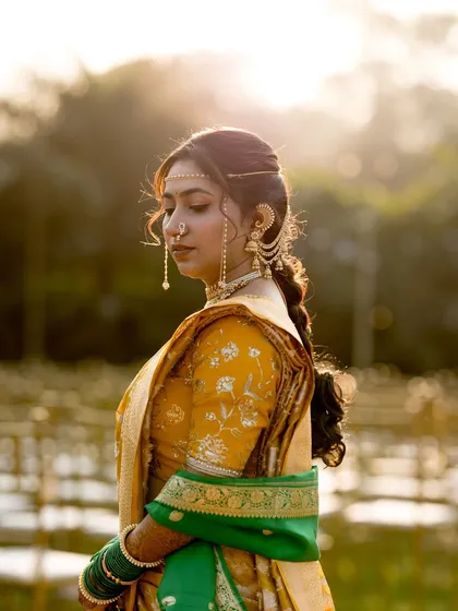 A side profile showcasing the bride's traditional braided hairstyle and elegant jewelry.