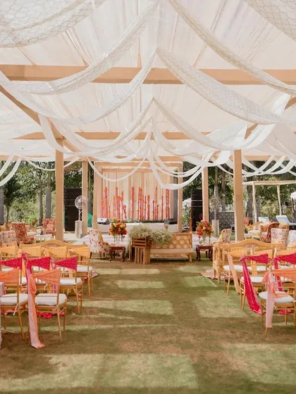 A wide view of the 'Rajasthani Folklore' Mehendi setup, showing the draped ceilings and various seating areas.