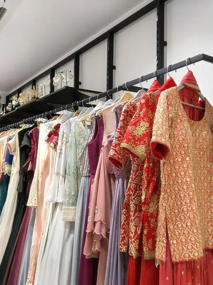 Another look at the variety on our clothing racks, showing everything from traditional red and gold embroidered suits to modern pastel gowns. There is truly something for every taste and occasion.