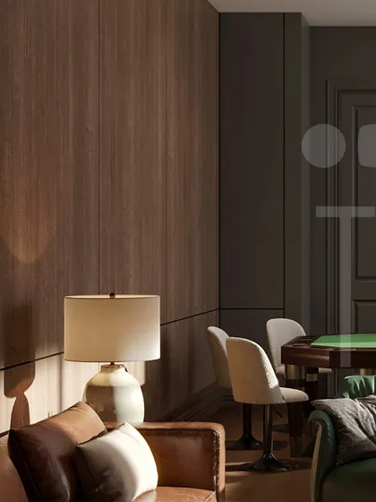 A view of the wood-paneled walls and a cozy seating area in the study. The table lamp provides a warm pool of light, perfect for reading or quiet contemplation.