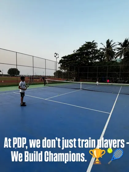 This wide shot shows a young player holding his ground on the baseline, ready for a rally. It reflects our motto: we don't just train players, we build champions.