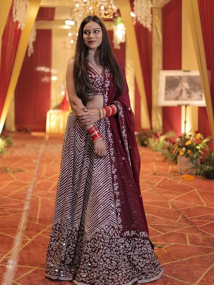 A beautiful shot of the client in her maroon chevron lehenga, ready for the celebration.