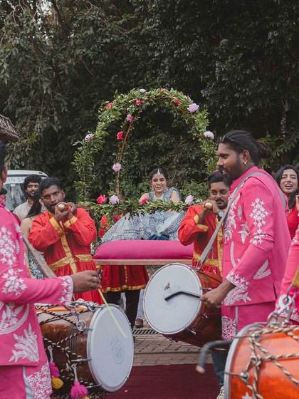 The bride's grand entrance on a doli, accompanied by dhol players. This is a moment of high energy and celebration, and we love being a part of such joyous traditions.