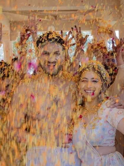 Priyangi and Kishan are showered with marigold petals during their haldi. The explosion of color and their joyful expressions perfectly capture the vibrant spirit of this pre-wedding ritual.