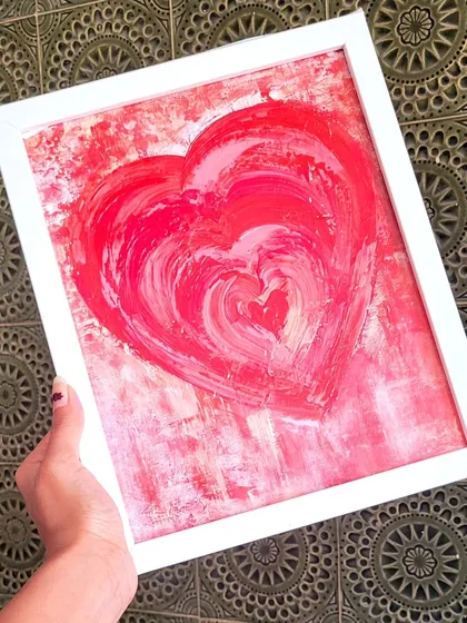 Holding this red heart painting, you can see how the different shades create a sense of depth. It's a piece about love in its many layers, perfect for gifting or as a daily reminder of self-love.