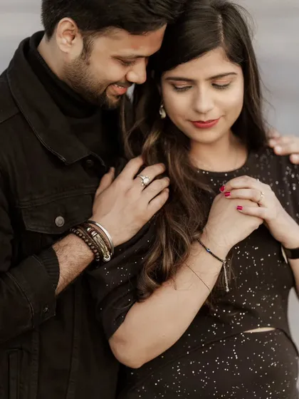 This image focuses on the details of their connection. The interlocking hands and gentle posture create a portrait that is both intimate and elegantly composed.