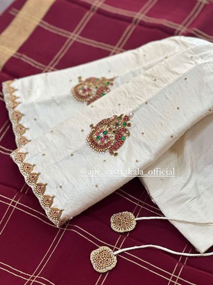 An elegant off-white blouse with delicate paisley motifs on the sleeves.