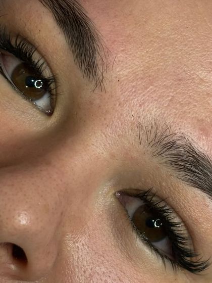 A stunning close up of a completed lash extension set. You can see the clean application and the beautiful curl that lifts the entire eye area. This is the result of our detailed and patient approach to lash artistry.